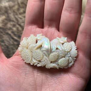 Vintage carved mother of pearl brooch of pineapple harvesters